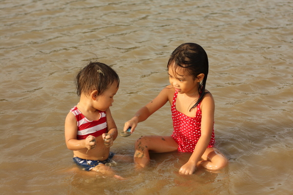 Girls feeding each other mudpies